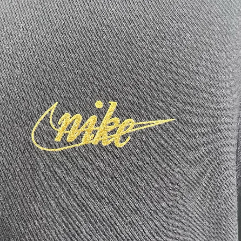 Nike Black long-sleeve t-shirt featuring metallic gold script logos Size Medium